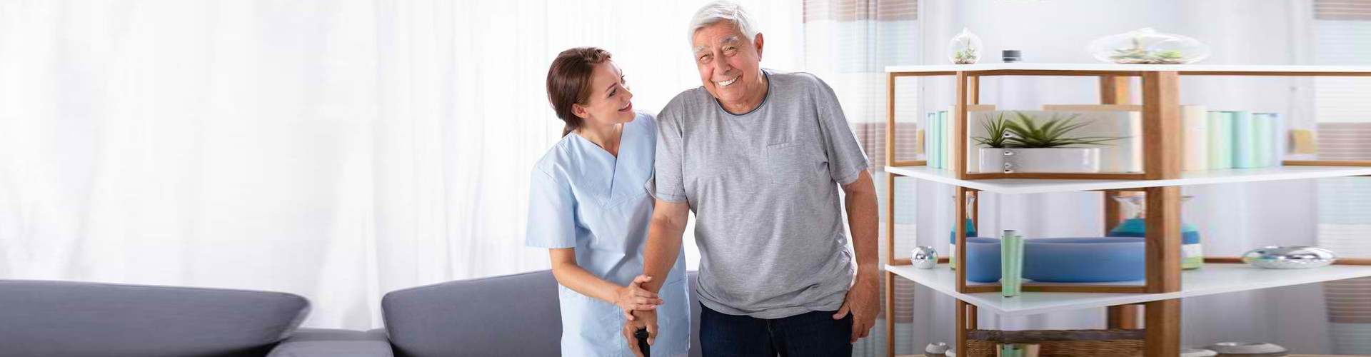 a caregiver and a senior woman looking at each other while smiling